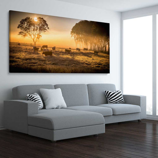 Animal wall art and canvas prints of Grazing Cattle at Sunrise on a stretched canvas displayed from an angle in a room
