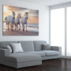 Animal wall art and canvas prints of Ocean Breeze Horses on a stretched canvas displayed from an angle in a room